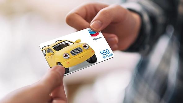 Carte-cadeau d'essence Chevron remise à quelqu'un.