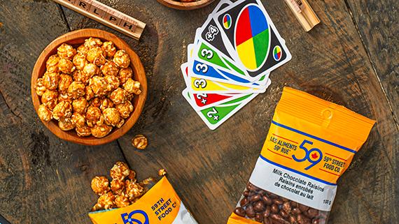 Snacks and boardgames on a wooden table.