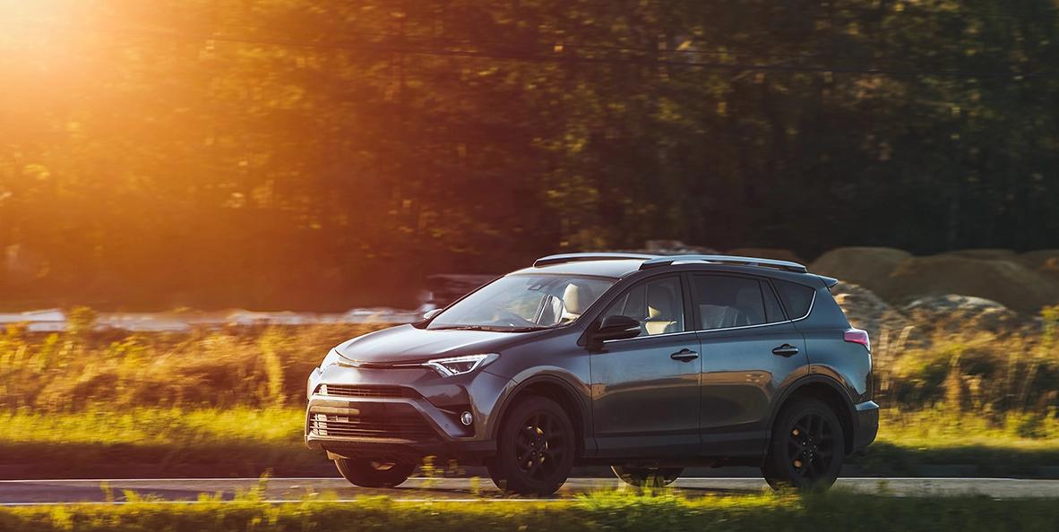 Voiture grise conduisant pendant un coucher de soleil.