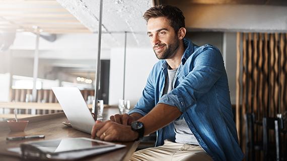 Man smiling while working on his computer.
